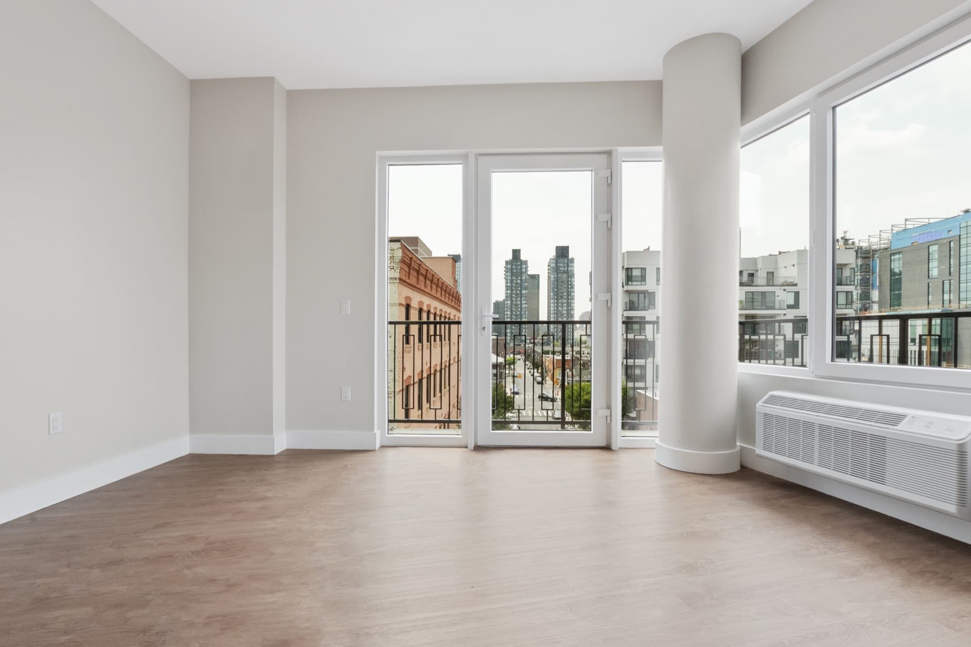 A residence at The Astelle at golden hour, balcony doors open to the Bronx skyline.