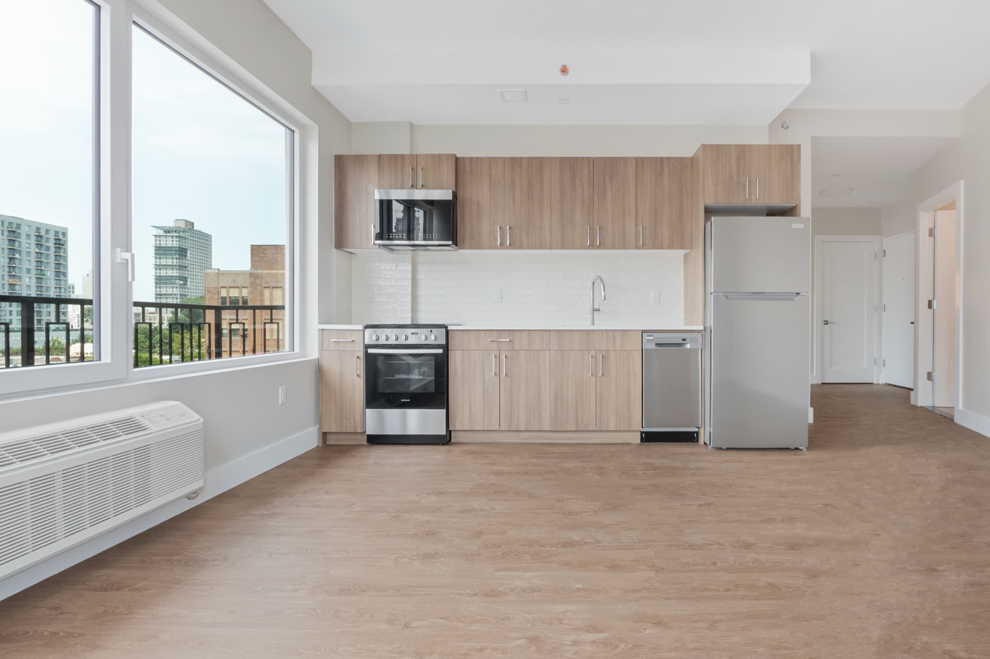 A residence interior at The Astelle at dusk, warm light against the city beyond